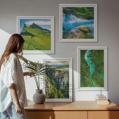 Billedvæg over sofa med motiv af grønne bjerge og flodklipper