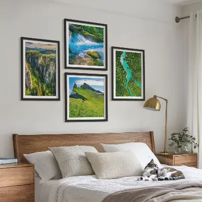 Billedvæg over sofa med motiv af grønne bjerge og flodklipper