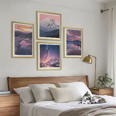 Billedvæg over sofa med motiv af bjerge, vand og smukke landskaber