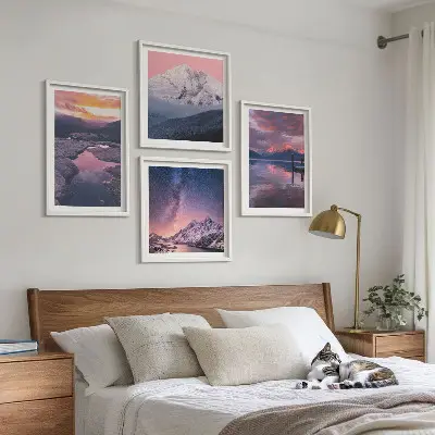 Billedvæg over sofa med motiv af bjerge, vand og smukke landskaber