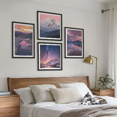 Billedvæg over sofa med motiv af bjerge, vand og smukke landskaber