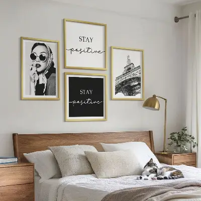 Billedvæg over sofa med portrætter og slogans af Eiffeltårnet