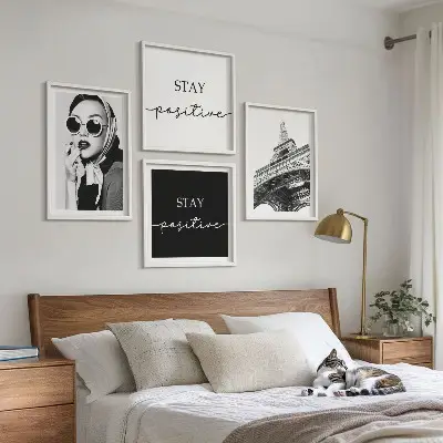 Billedvæg over sofa med portrætter og slogans af Eiffeltårnet