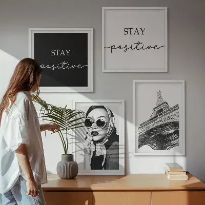 Billedvæg over sofa med portrætter og slogans af Eiffeltårnet
