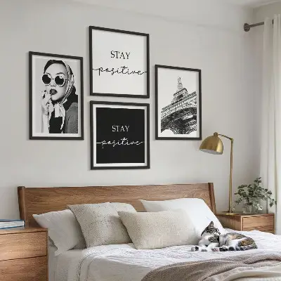 Billedvæg over sofa med portrætter og slogans af Eiffeltårnet