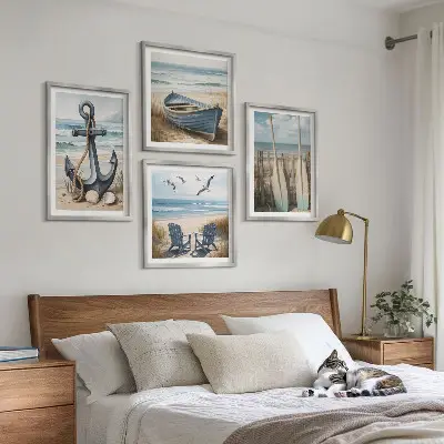 Billedvæg over sofa med motiv af anker, båd, årer og strand