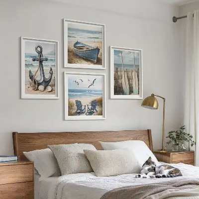 Billedvæg over sofa med motiv af anker, båd, årer og strand