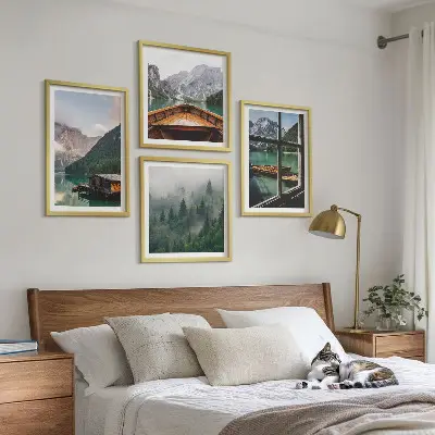 Billedvæg over sofa med motiv af bjergsø og hytter
