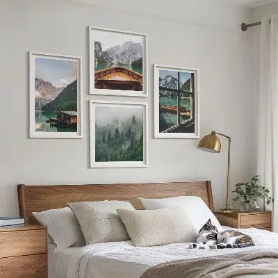 Billedvæg over sofa med motiv af bjergsø og hytter