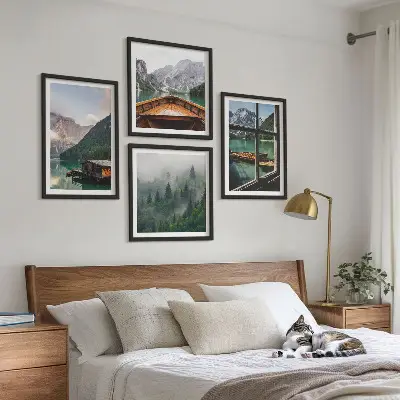 Billedvæg over sofa med motiv af bjergsø og hytter