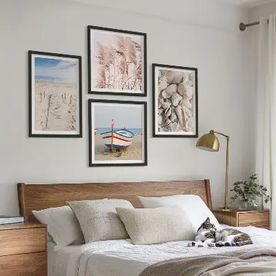 Billedvæg over sofa med strand, båd, skaller og boho-græs