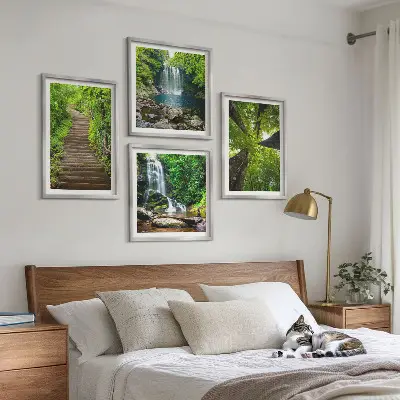 Billedvæg over sofa med motiv af skovsti ved vandfald og vegetation