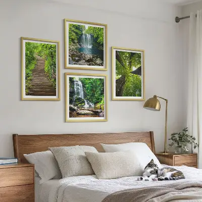 Billedvæg over sofa med motiv af skovsti ved vandfald og vegetation