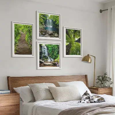 Billedvæg over sofa med motiv af skovsti ved vandfald og vegetation