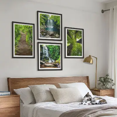 Billedvæg over sofa med motiv af skovsti ved vandfald og vegetation