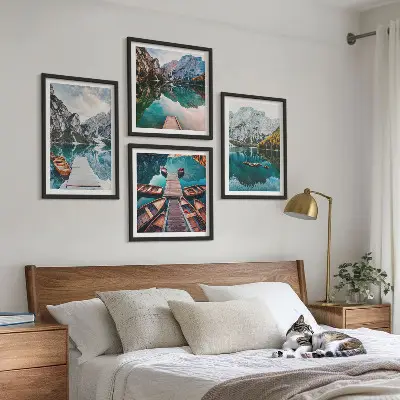 Billedvæg over sofa med motiv af sø, broer og bjerge