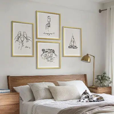 Billedvæg over sofa med motiv af hus på vandet og sejlbåd