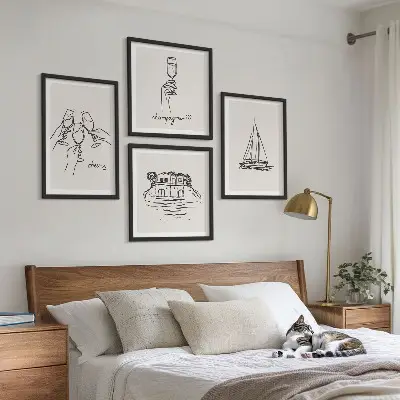Billedvæg over sofa med motiv af hus på vandet og sejlbåd