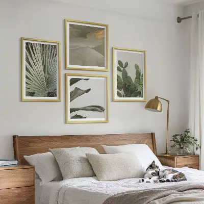 Billedvæg over sofa med blade af tropiske planter i pastel