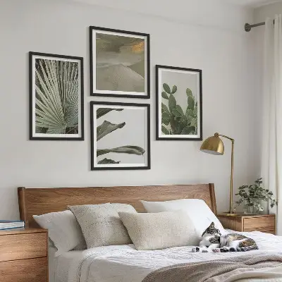 Billedvæg over sofa med blade af tropiske planter i pastel