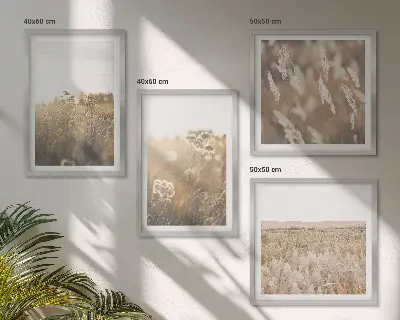 Billedvæg over sofa med motiv af landskabsgræs og blomster i varme nuancer