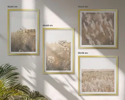 Billedvæg over sofa med motiv af landskabsgræs og blomster i varme nuancer
