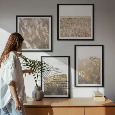 Billedvæg over sofa med motiv af landskabsgræs og blomster i varme nuancer