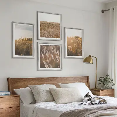 Billedvæg med sommerenge motiver af blomster i solnedgang over sofa