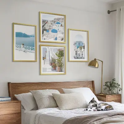 Billedvæg over sofa med motiv af hvide trapper, planter og hav