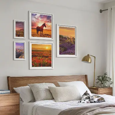 Billedsæt over sofa med motiv af landskaber med naturheste og blomster
