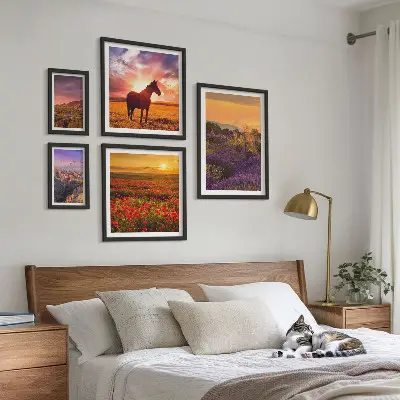 Billedsæt over sofa med motiv af landskaber med naturheste og blomster