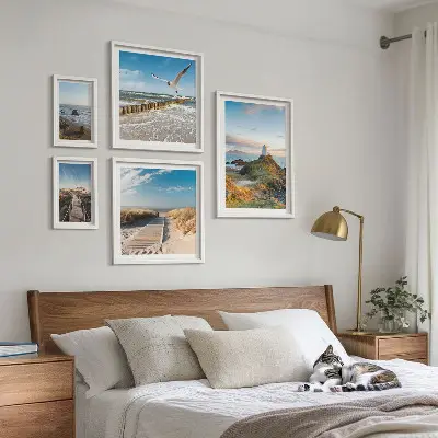 Billedsæt over sofa med motiv af fyrtårne og strande ved havet