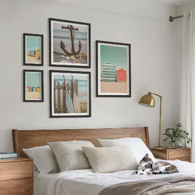 Billedsæt over sofa med motiv af stilfulde strandhuse ved havet