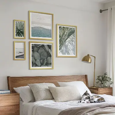 Billedsæt over sofa med motiv af tropiske planter ved havet