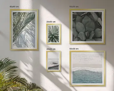Billedsæt over sofa med motiv af tropiske planter ved havet